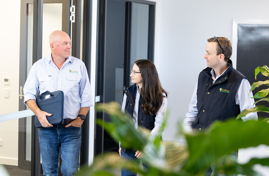 Cowal Ag team member with two clients walking outside their office.